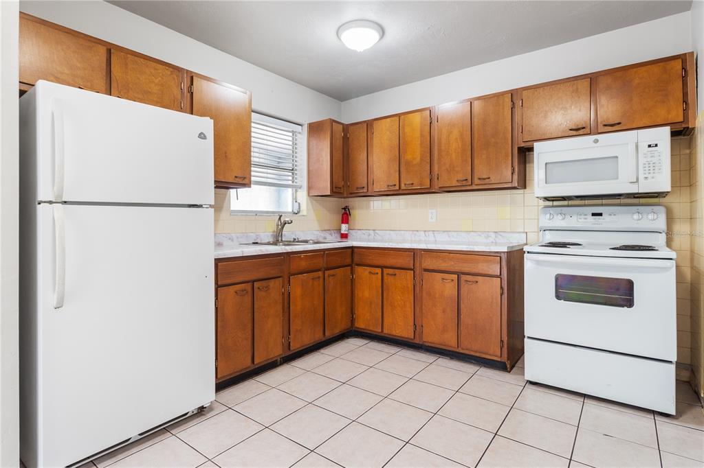 7208 Fair Oaks Street Spring Hill, FL 34606 - Photo 8 of 25 a kitchen with a refrigerator sink and cabinets
