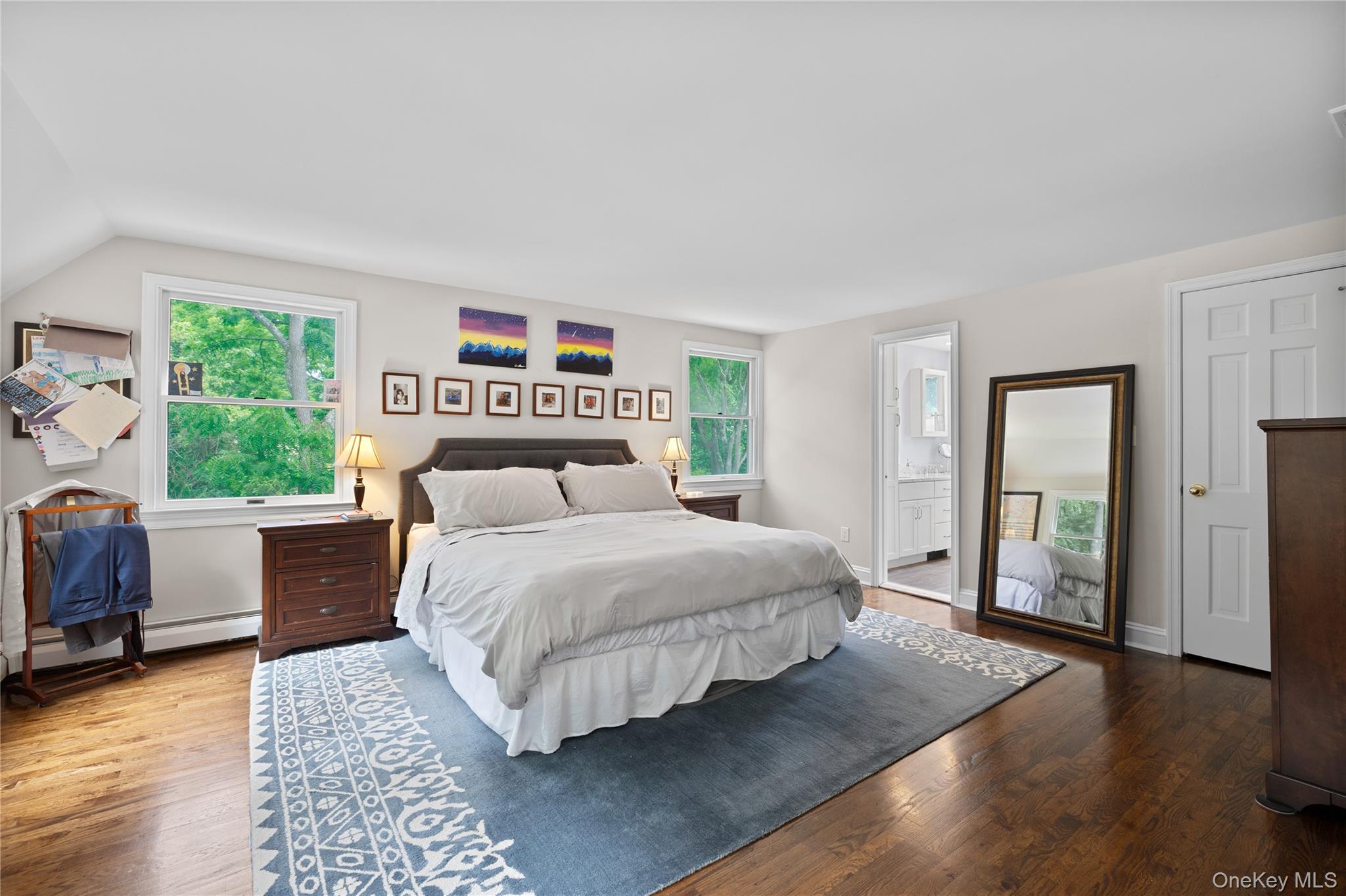 9 Three Sisters Road St. James, NY 11780 - Photo 12 of 36 Spacious Primary suite with polished wood-finish flooring, multiple windows, and a neutral color palette