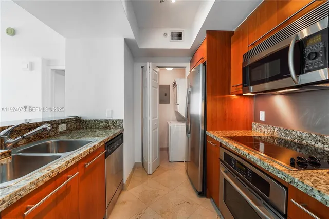 a kitchen with stainless steel appliances granite countertop a sink and a stove