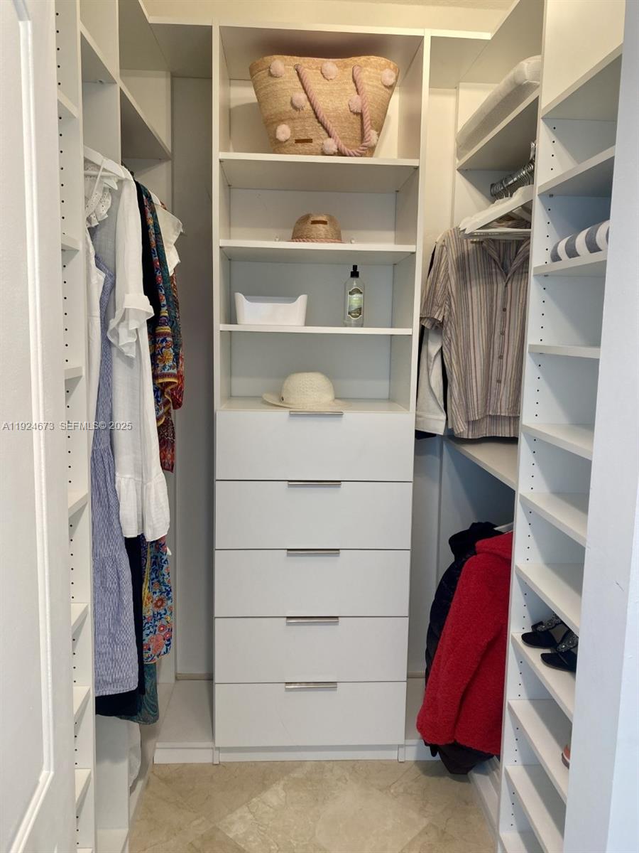 110 Washington Avenue, Unit 1822 Miami Beach, FL 33139 - Photo 8 of 17 a view of walk in closet with clothes and shoes