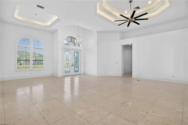 a view of an empty room with a window and kitchen view