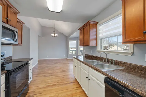 a kitchen with granite countertop a sink stainless steel appliances and cabinets