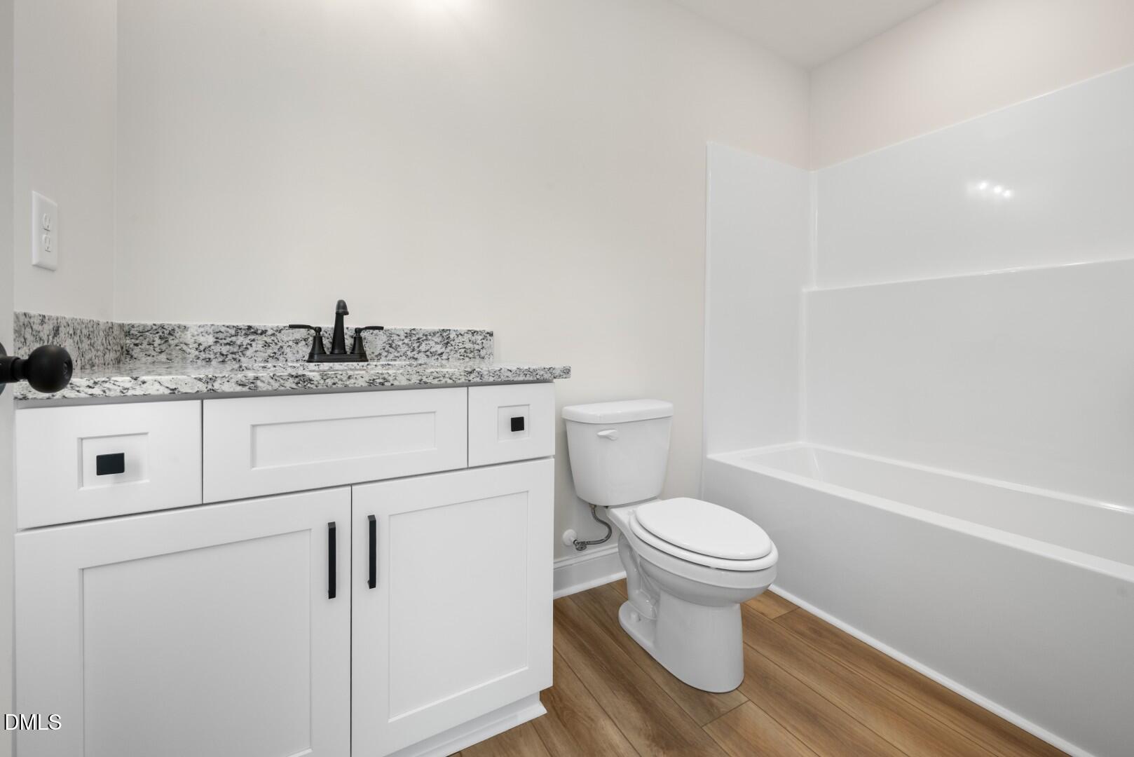 2251 Peachtree Hills Road Spring Hope, NC 27882 - Photo 34 of 46 a bathroom with a granite countertop toilet a sink and a mirror