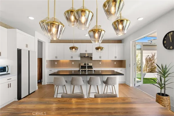 a kitchen with stainless steel appliances granite countertop a sink a stove and a refrigerator