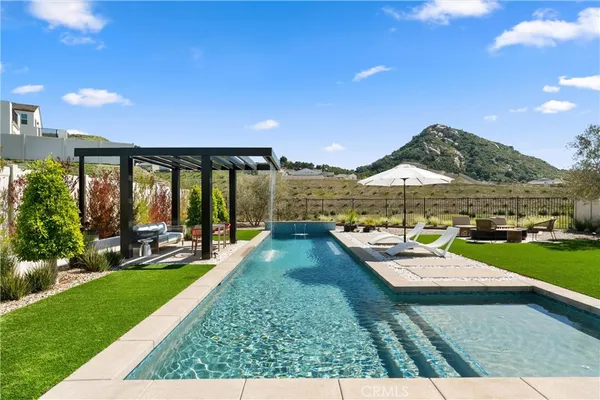a front view of a house with swimming pool having outdoor seating