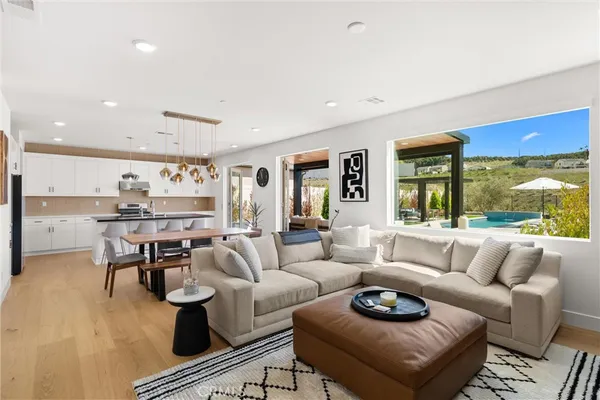 a dining room with stainless steel appliances kitchen island granite countertop a table chairs and a refrigerator
