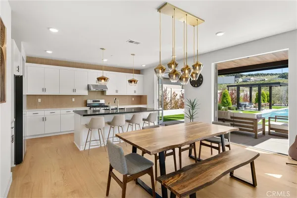 a kitchen with stainless steel appliances granite countertop a refrigerator and a stove top oven