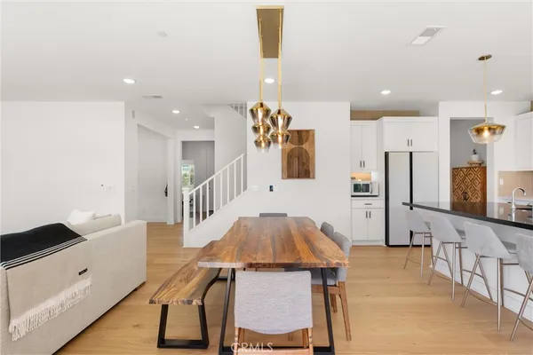 a kitchen with kitchen island stainless steel appliances a table and chairs in it