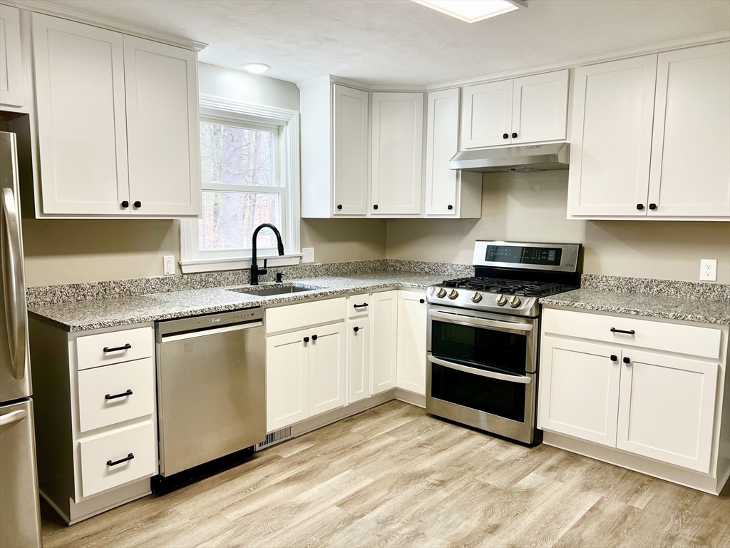 12 Sargent Lane Franklin, MA 02038 - Photo 12 of 40 a kitchen with granite countertop white cabinets and stainless steel appliances