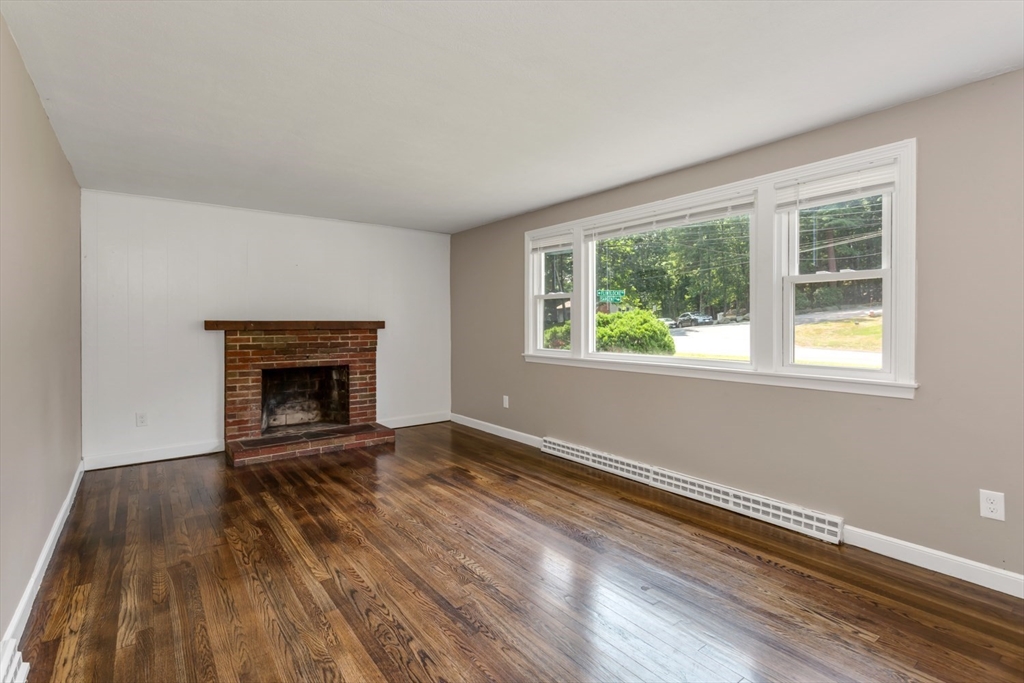 12 Sargent Lane Franklin, MA 02038 - Photo 7 of 40 a view of empty room with wooden floor and fireplace