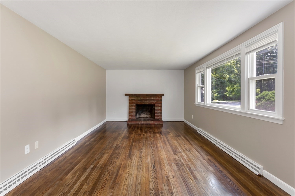 12 Sargent Lane Franklin, MA 02038 - Photo 9 of 40 a view of an empty room with wooden floor fireplace and a window