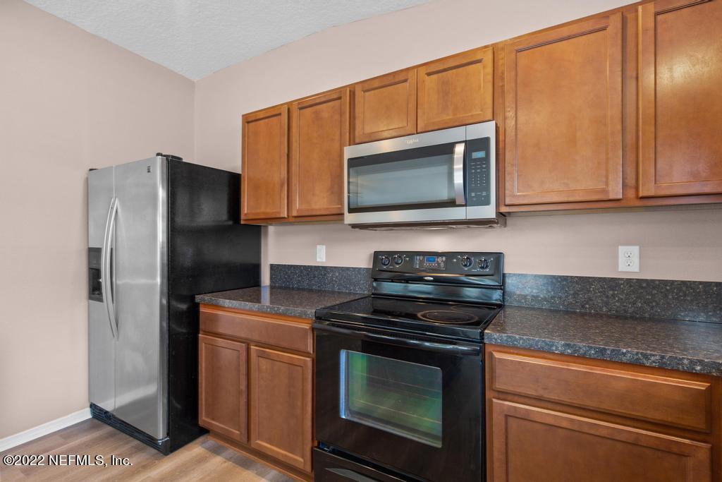 2527 Eisner Drive Jacksonville, FL 32218 - Photo 11 of 29 a kitchen with granite countertop wooden cabinets and stainless steel appliances