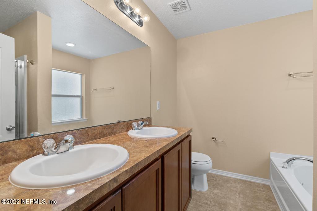 2527 Eisner Drive Jacksonville, FL 32218 - Photo 15 of 29 a bathroom with a granite countertop sink a toilet and a mirror