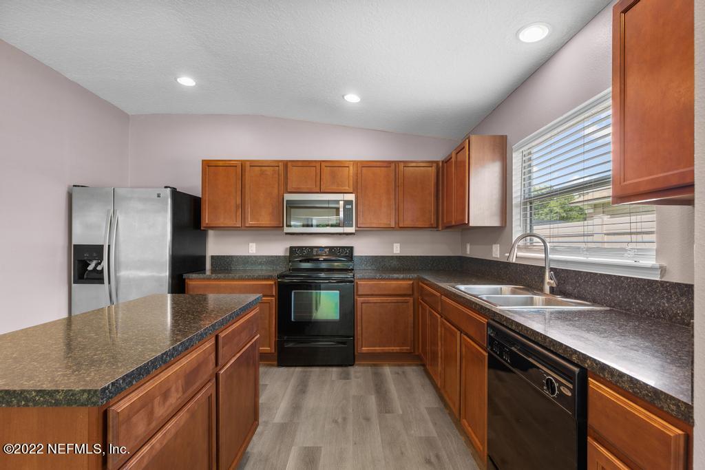 2527 Eisner Drive Jacksonville, FL 32218 - Photo 9 of 29 a kitchen with stainless steel appliances granite countertop a sink stove and refrigerator