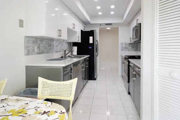 a kitchen with stainless steel appliances a sink dishwasher stove refrigerator and cabinets