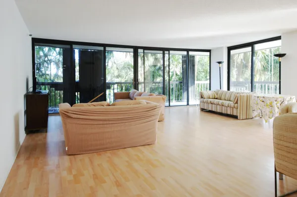 a living room with furniture and floor to ceiling windows