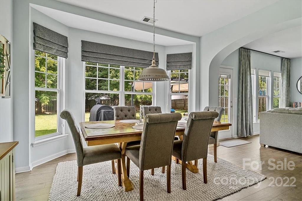 244 Sand Paver Way, Unit 60 Fort Mill, SC 29708 - Photo 14 of 42 a dining room with furniture large windows and wooden floor