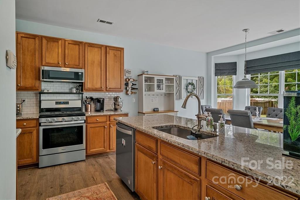 244 Sand Paver Way, Unit 60 Fort Mill, SC 29708 - Photo 19 of 42 a kitchen with stainless steel appliances granite countertop a stove a sink and a granite counter tops