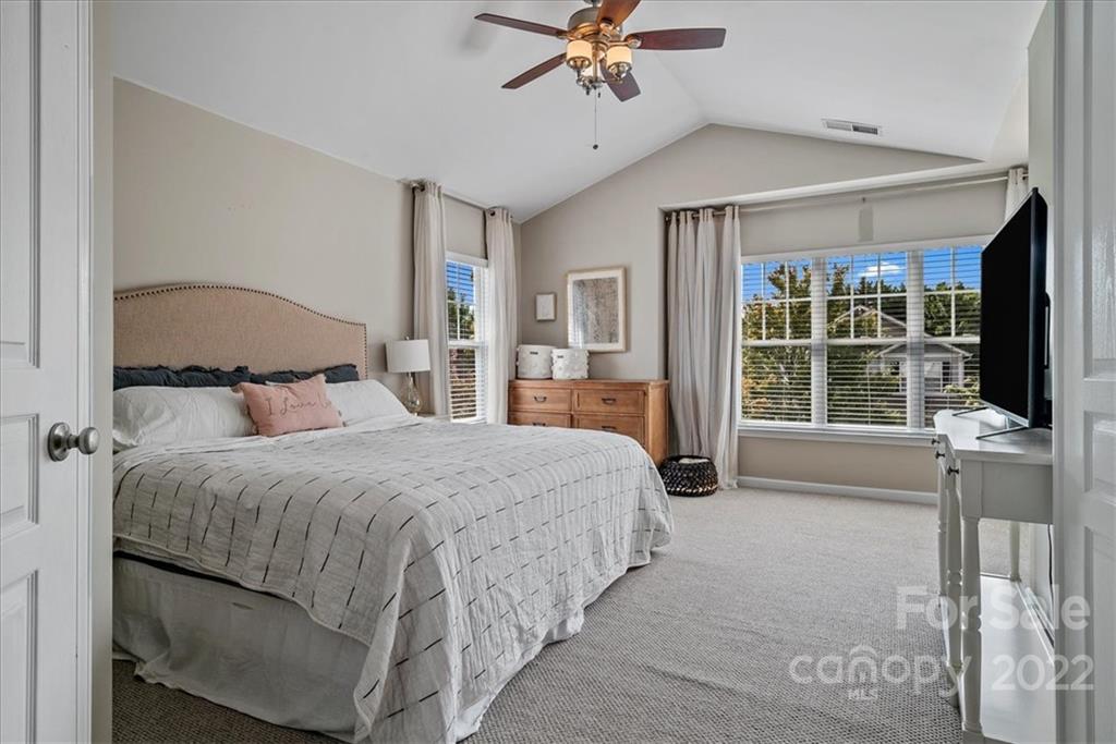 244 Sand Paver Way, Unit 60 Fort Mill, SC 29708 - Photo 21 of 42 a bedroom with a large bed and a chandelier