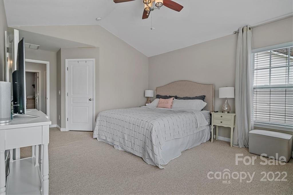 244 Sand Paver Way, Unit 60 Fort Mill, SC 29708 - Photo 22 of 42 a bedroom with a bed and a chandelier