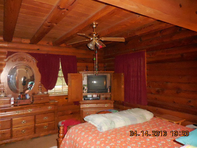 4061 Johnstonville Road Forsyth, GA 31029 - Photo 6 of 8 a bedroom with a bed and a chandelier