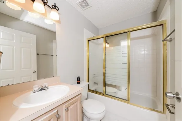a bathroom with a sink mirror shower and toilet