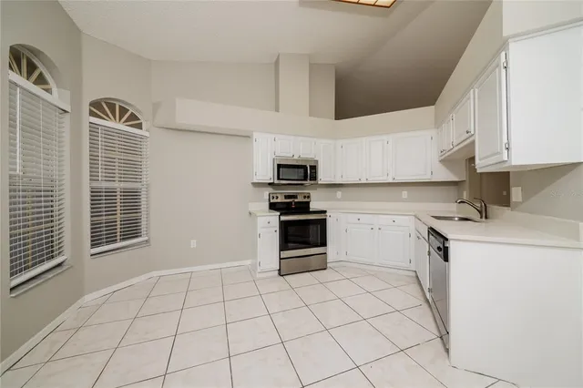 a kitchen with granite countertop a stove top oven and cabinets