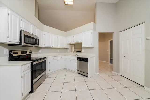 a kitchen with white cabinets a sink and white appliances