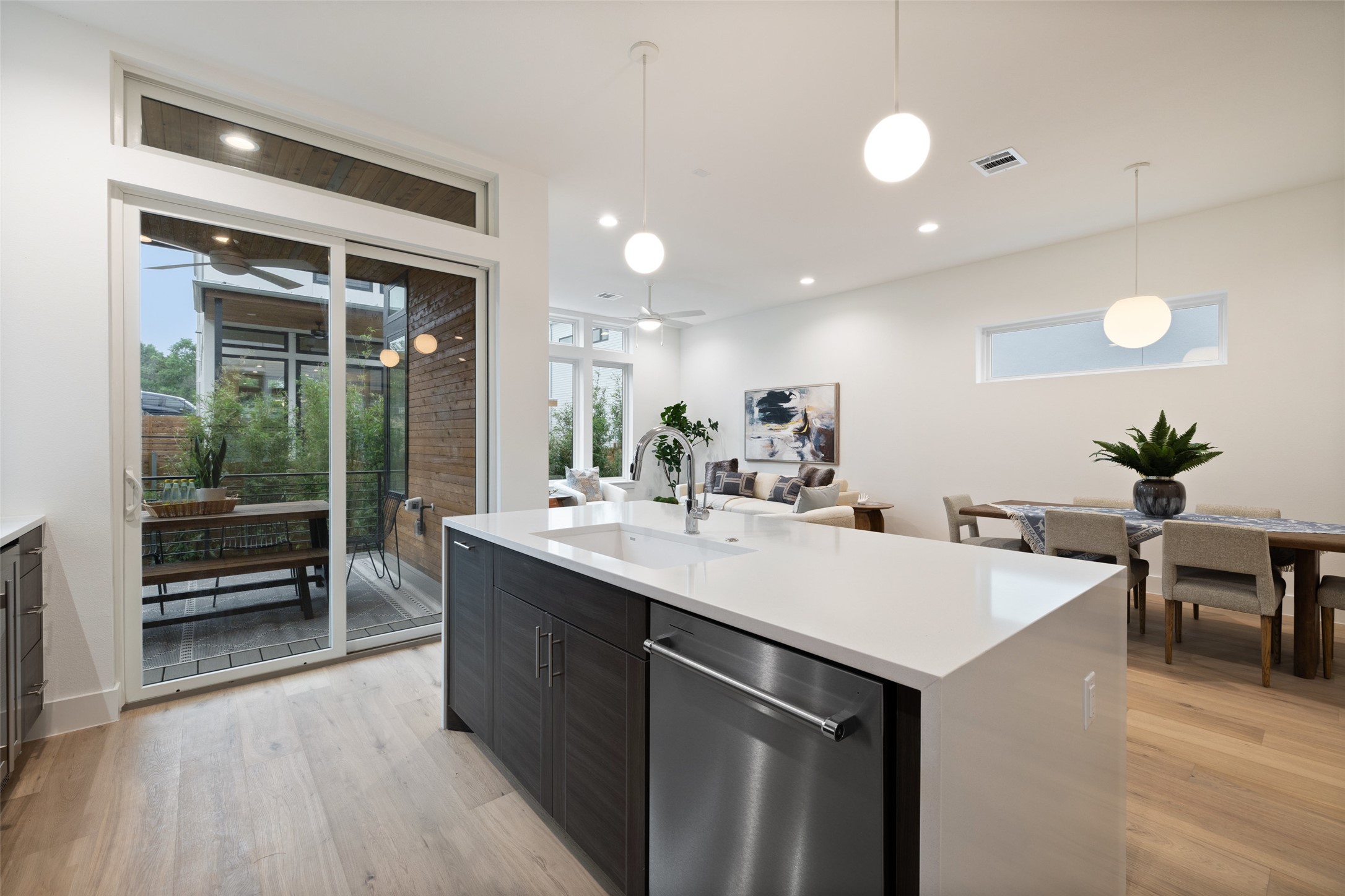 900 South 2nd Street, Unit 20 Austin, TX 78704 - Photo 14 of 40 a kitchen with kitchen island a sink appliances and a dining table with wooden floor
