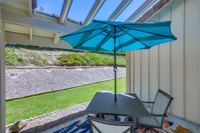 a table and chair under an umbrella in backyard
