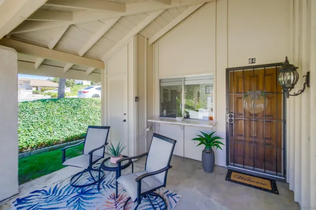 a view of a porch with chairs and potted plants