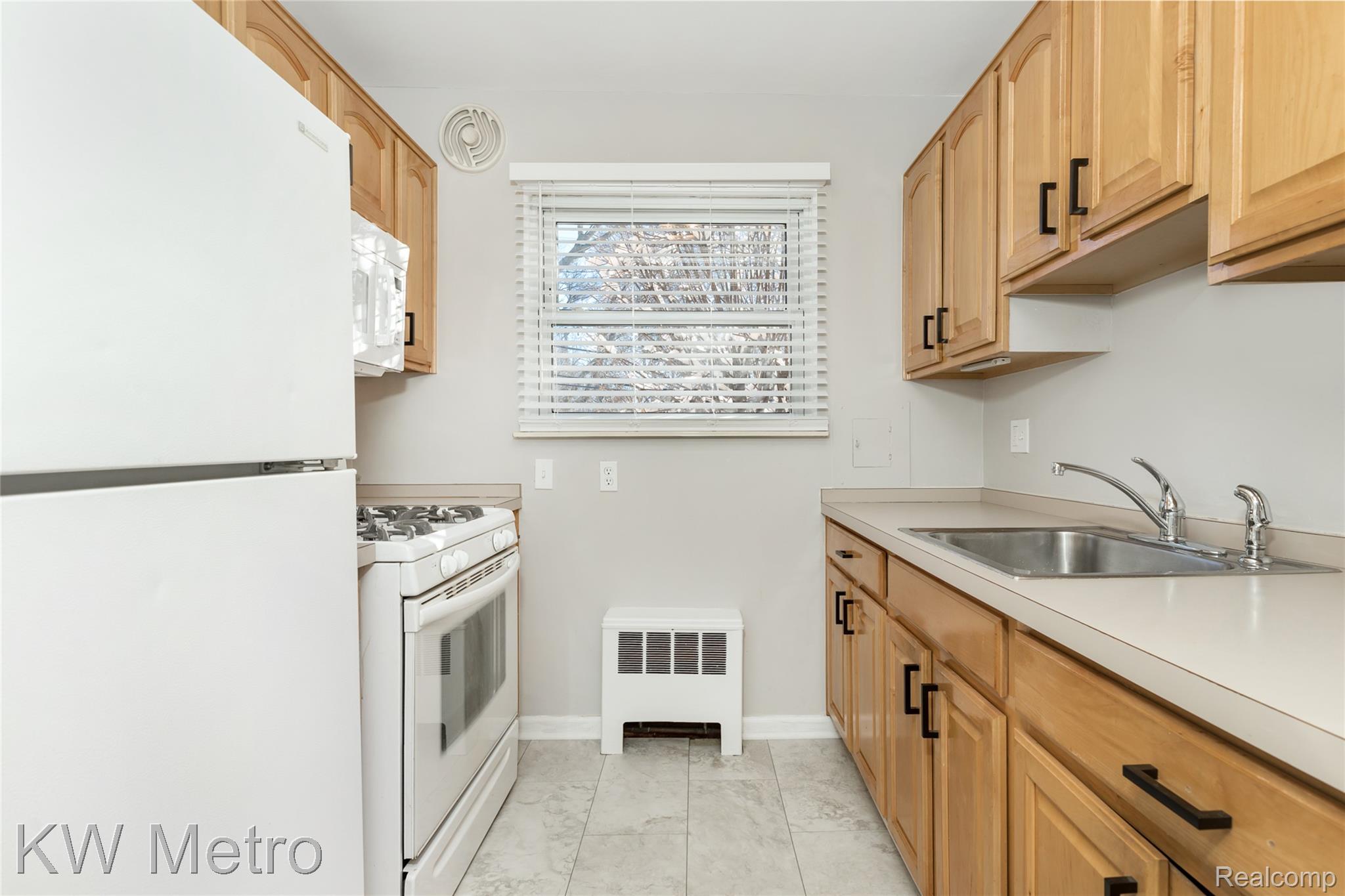 2817 West 13 Mile Road Royal Oak, MI 48073 - Photo 8 of 21 Kitchen with white appliances, light countertops, and radiator