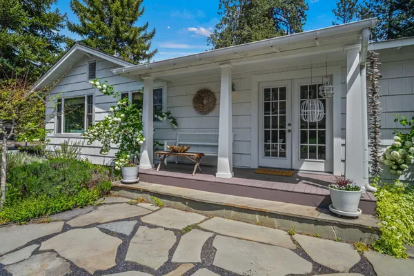 a view of a house with a yard and potted plants