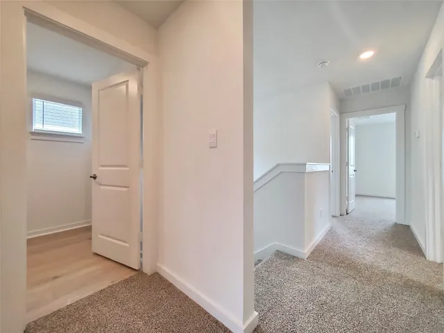 a view of a hallway with closet and wooden floor