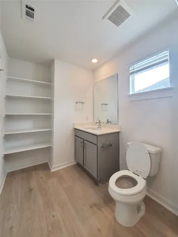 a bathroom with a toilet sink vanity and mirror