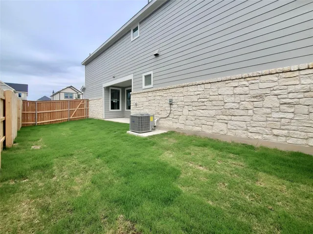 a view of a backyard with plants and large tree
