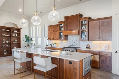 a kitchen with a sink a counter and chairs in it