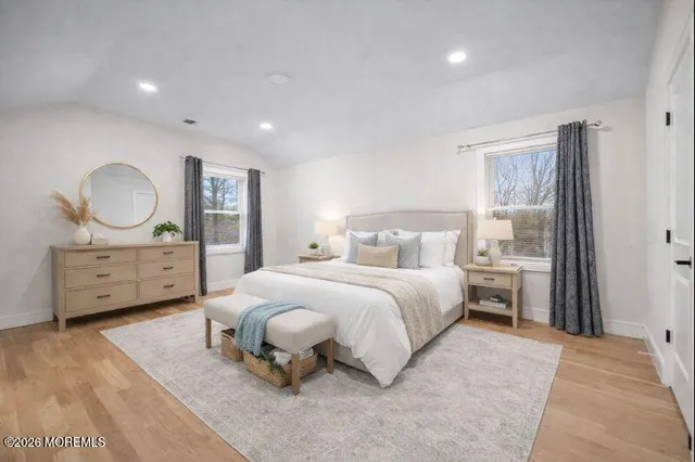 a bedroom with a bed mirror and window