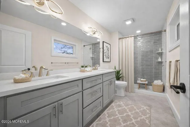 a spacious bathroom with a double vanity sink mirror and bathtub