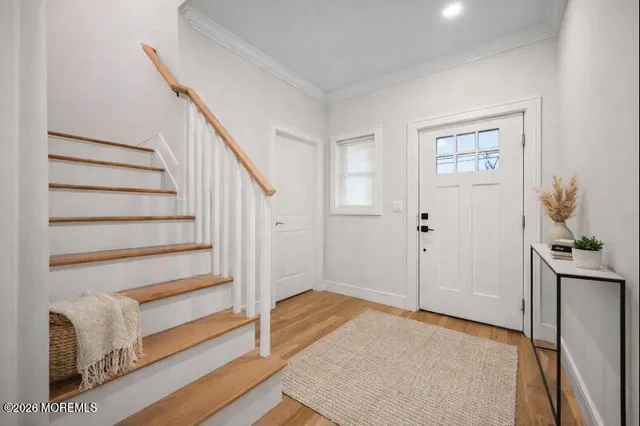a view of entryway with wooden floor and stairs