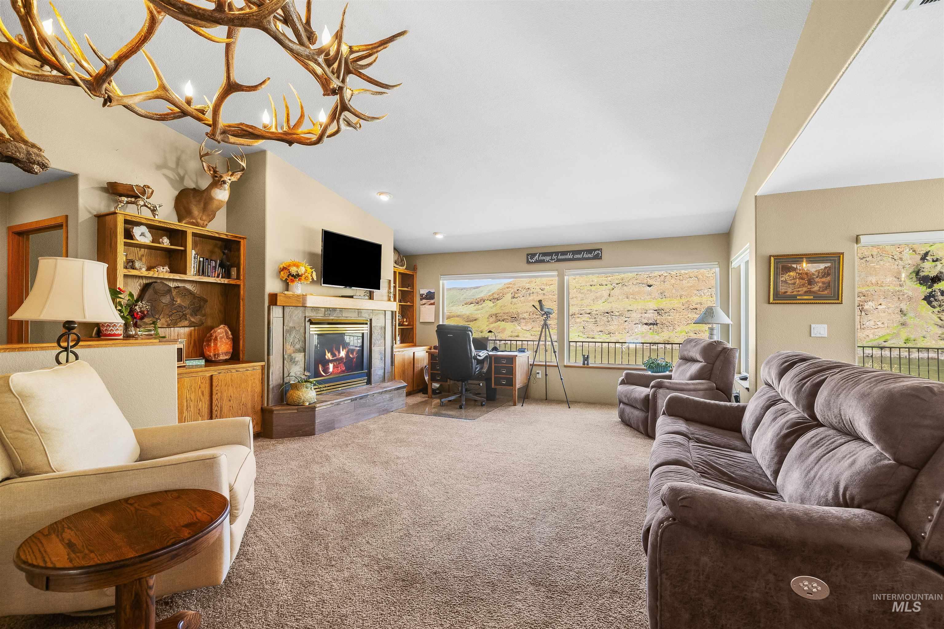 11056 Snake River Road Asotin, WA 99402 - Photo 13 of 50 Living area featuring a tiled fireplace, carpet flooring, lofted ceiling, and suspended lighting