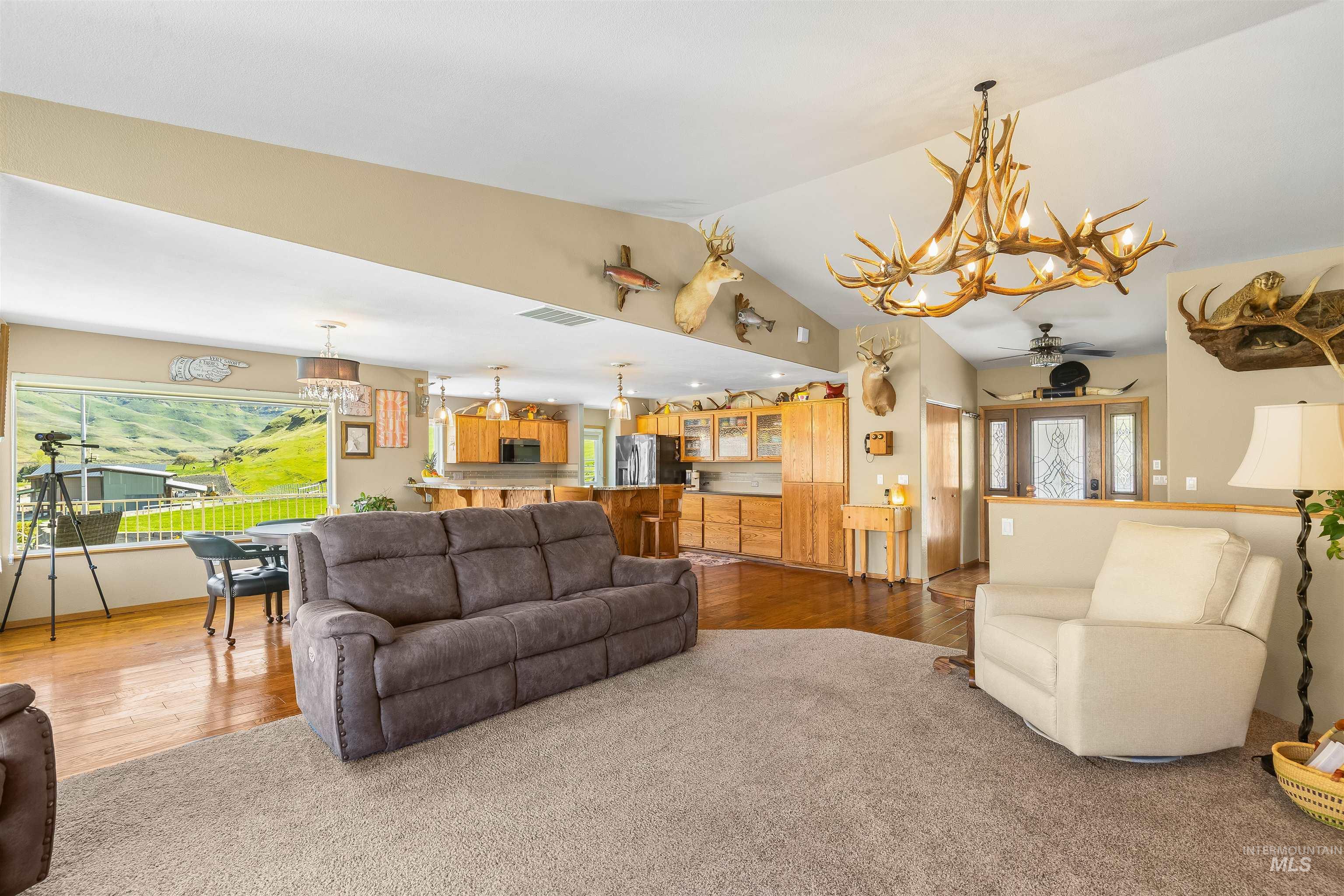 11056 Snake River Road Asotin, WA 99402 - Photo 14 of 50 Living room featuring a chandelier, a ceiling fan, hardwood / wood-style flooring, and carpet flooring