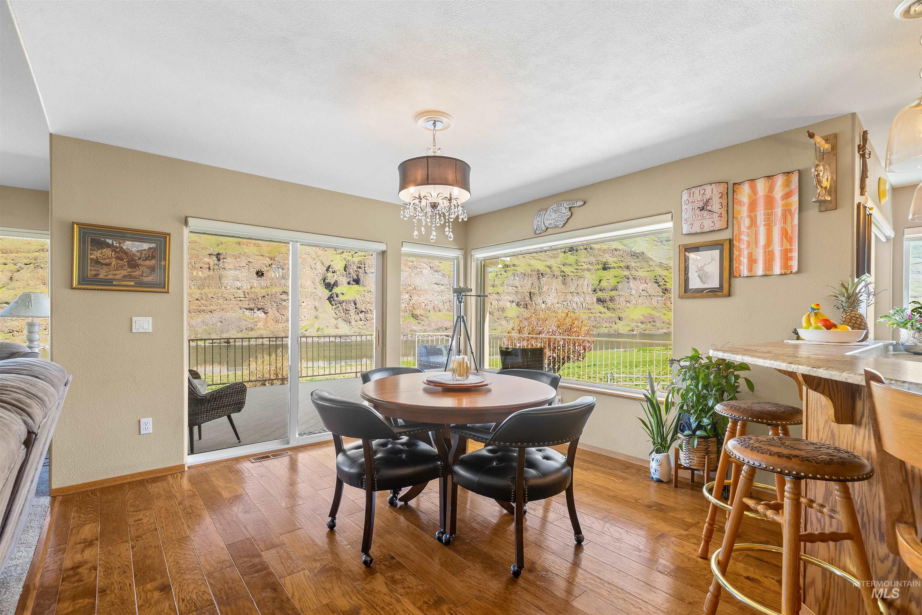 11056 Snake River Road Asotin, WA 99402 - Photo 18 of 50 Dining room featuring a chandelier, light wood finished floors, and plenty of natural light