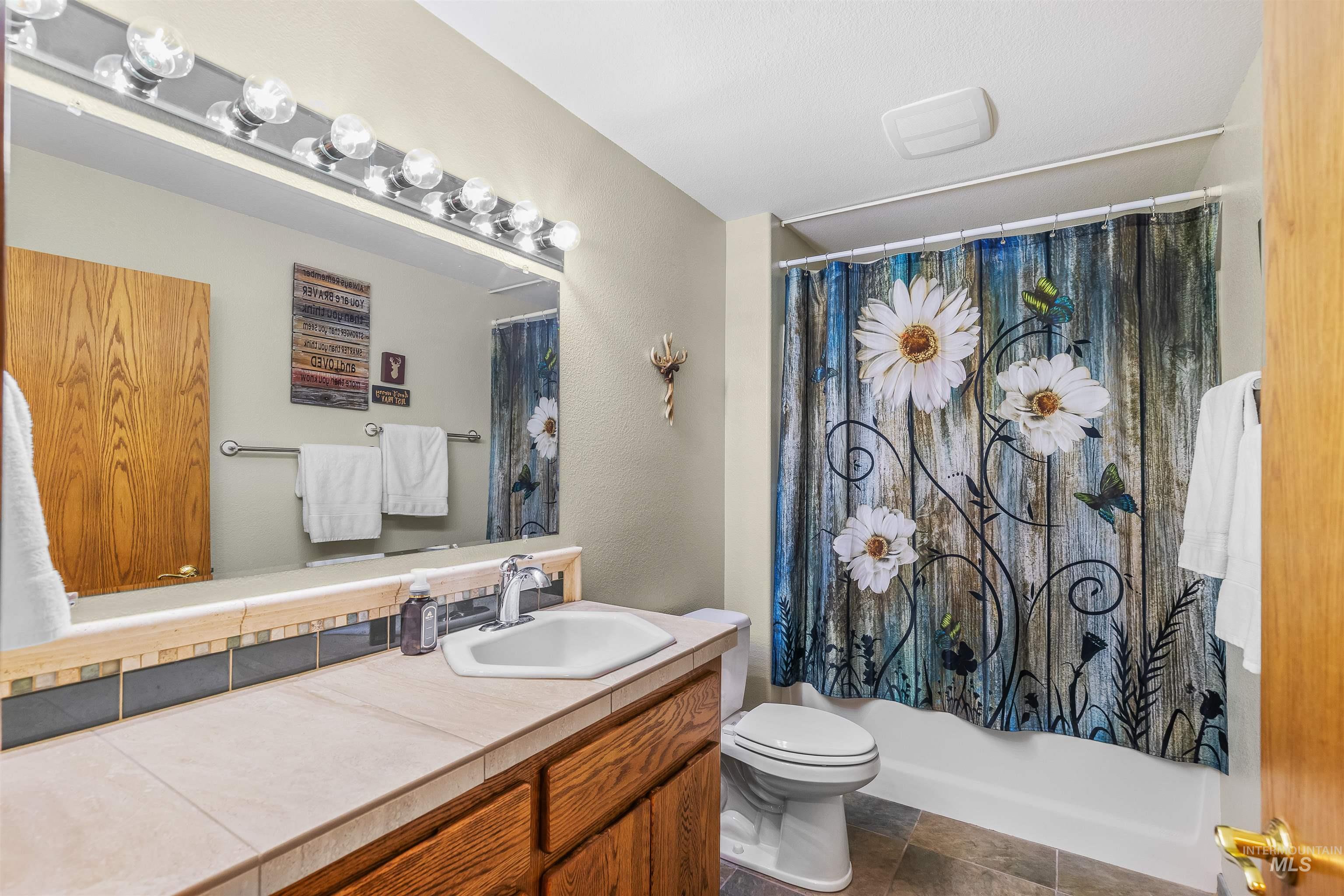 11056 Snake River Road Asotin, WA 99402 - Photo 21 of 50 Bathroom featuring vanity, a textured wall, and shower / bath combination with curtain