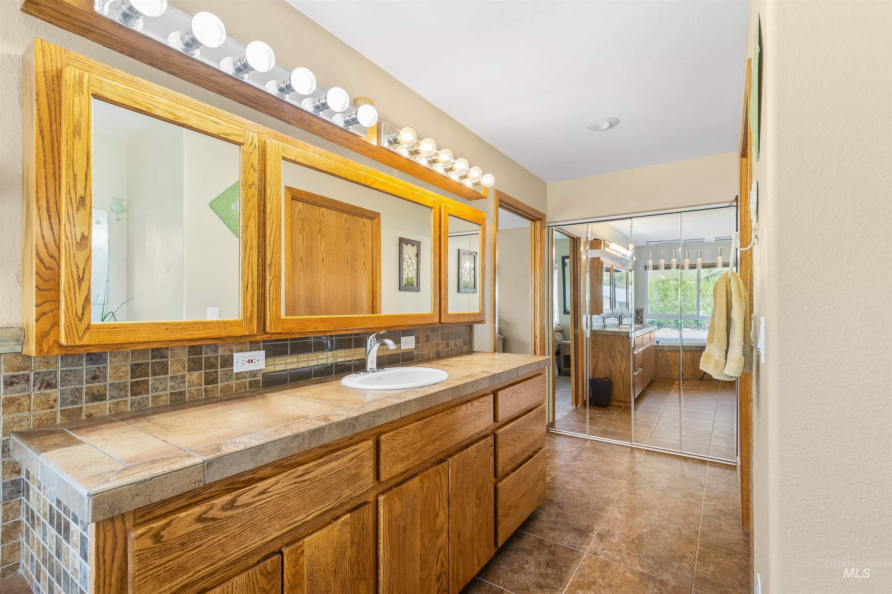 11056 Snake River Road Asotin, WA 99402 - Photo 24 of 50 Full bath featuring vanity, tasteful backsplash, and dark tile patterned floors