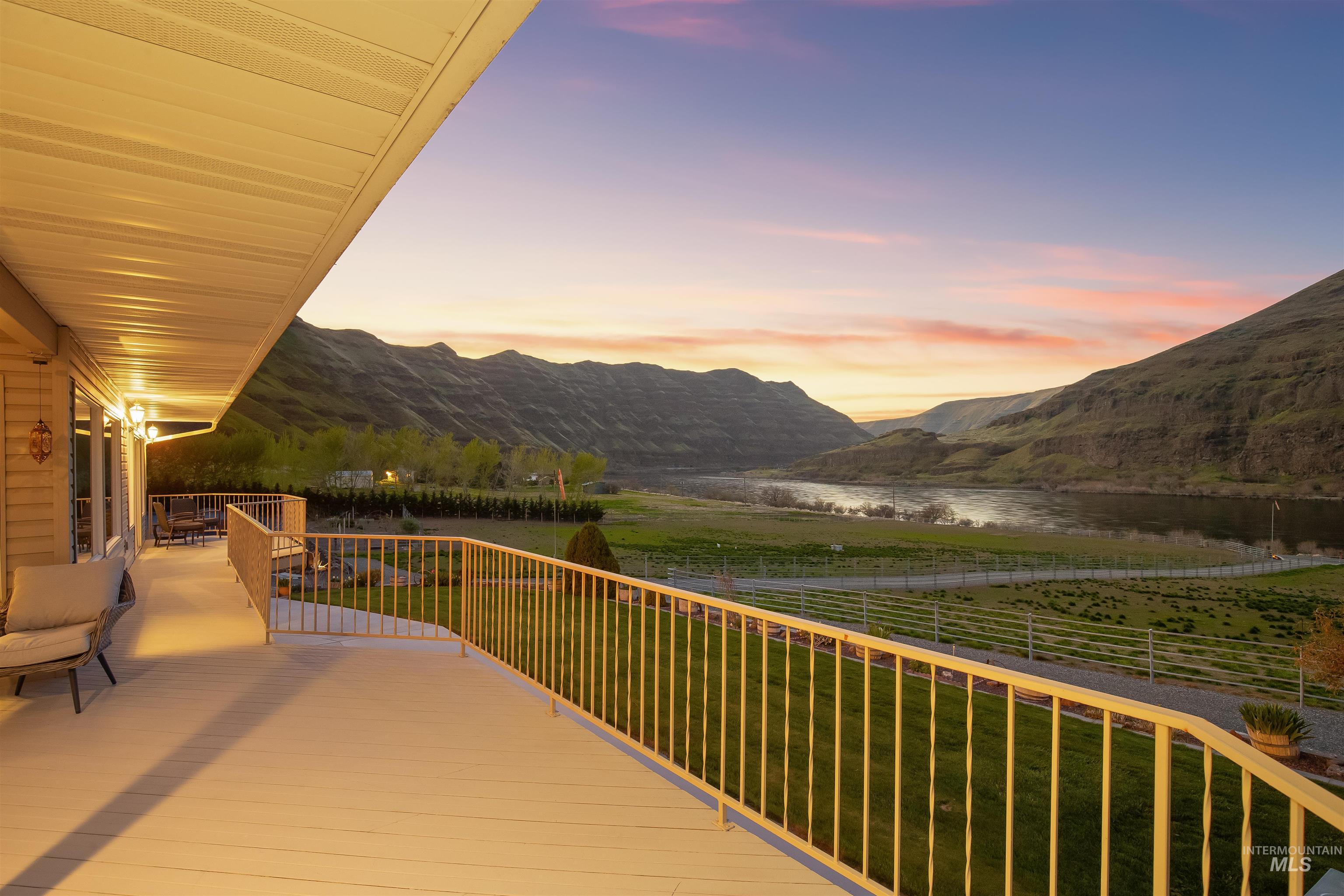 11056 Snake River Road Asotin, WA 99402 - Photo 4 of 50 Deck at dusk featuring a water and mountain view and a lawn