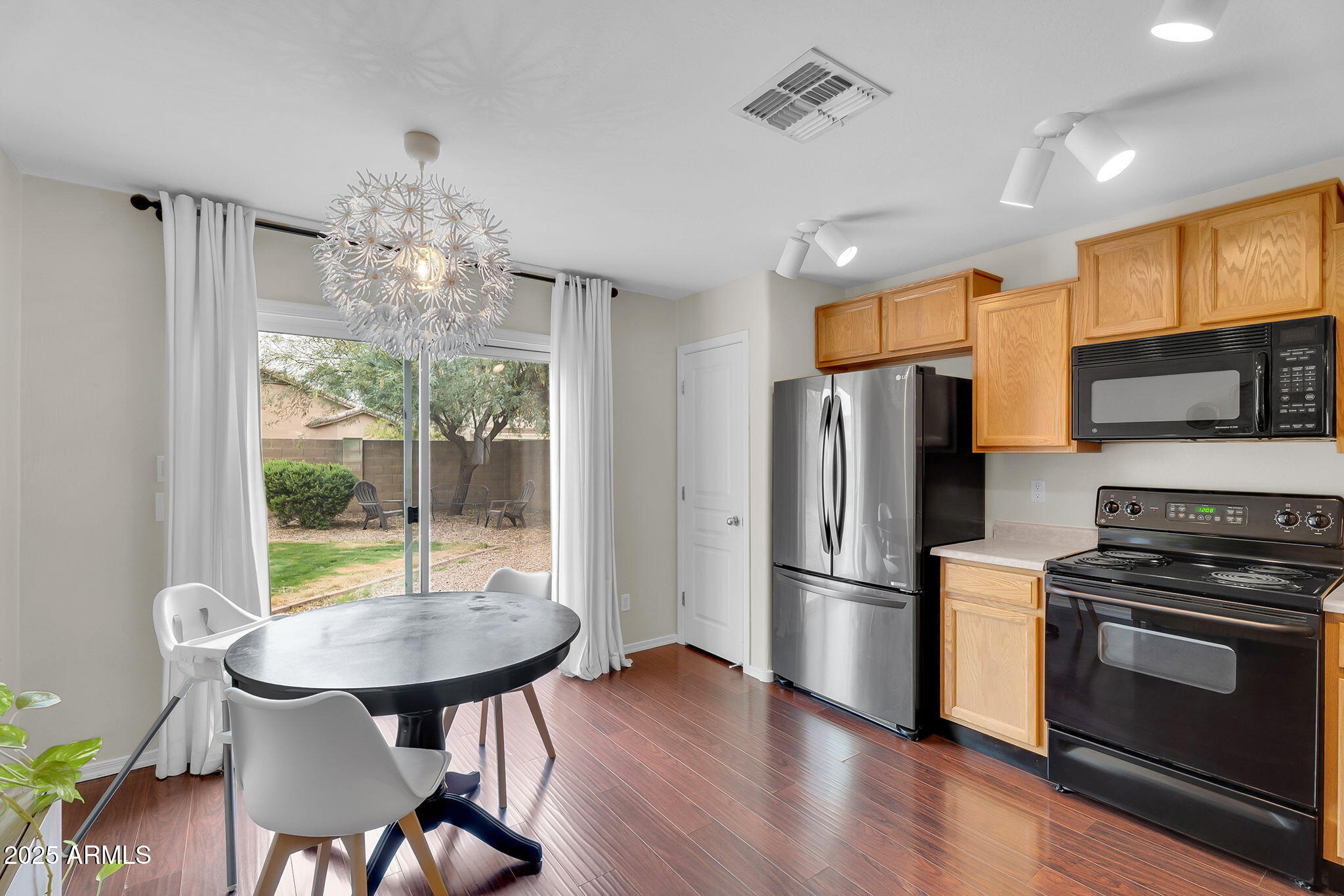 4013 East Superior Road San Tan Valley, AZ 85143 - Photo 8 of 31 a kitchen with stainless steel appliances wooden floor dining table and chairs
