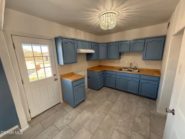 a view of a kitchen with a sink dishwasher and wooden floor