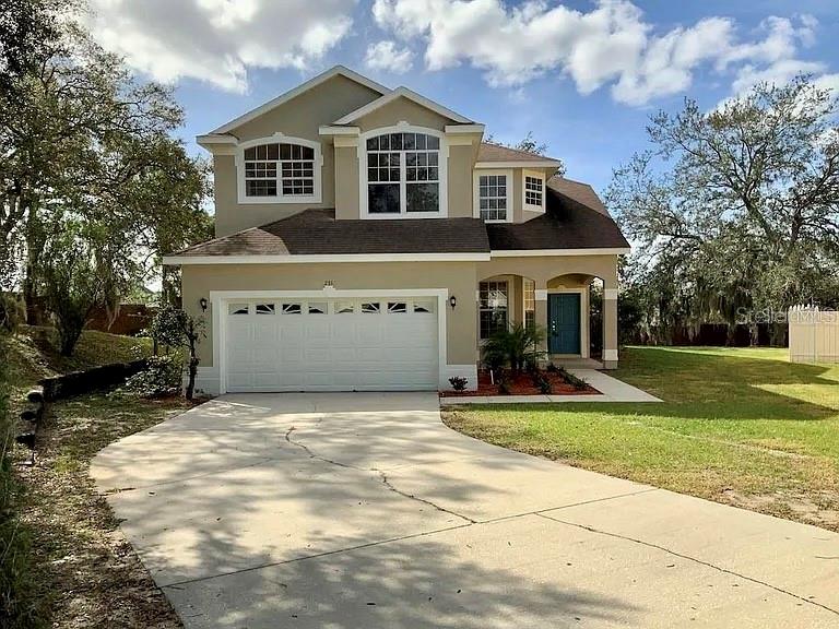 a front view of a house with a yard and garage