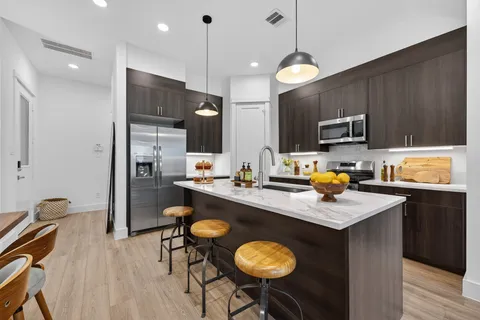 a kitchen with a table chairs refrigerator and microwave